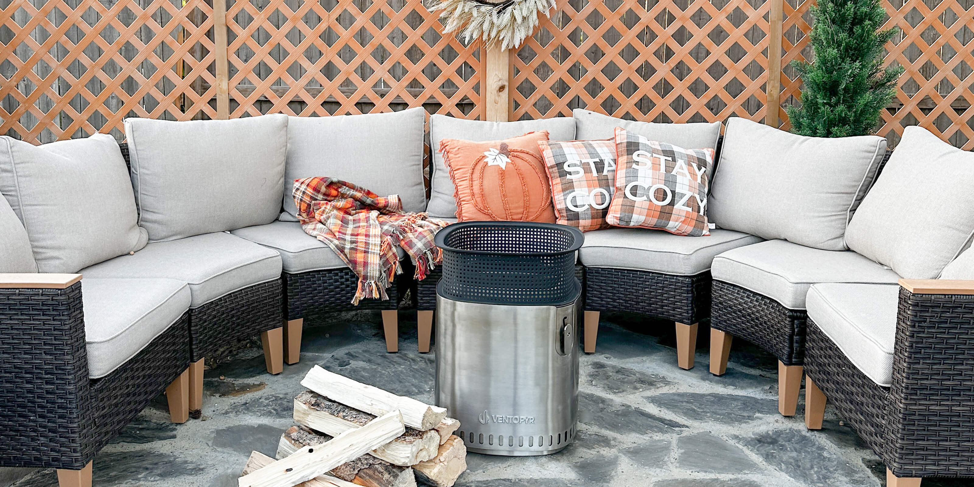 A fire pit is placed in front of an outdoor sofa