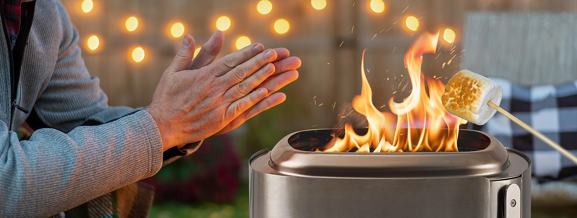 A man is sitting in front of a smokeless fireplace, warming himself.