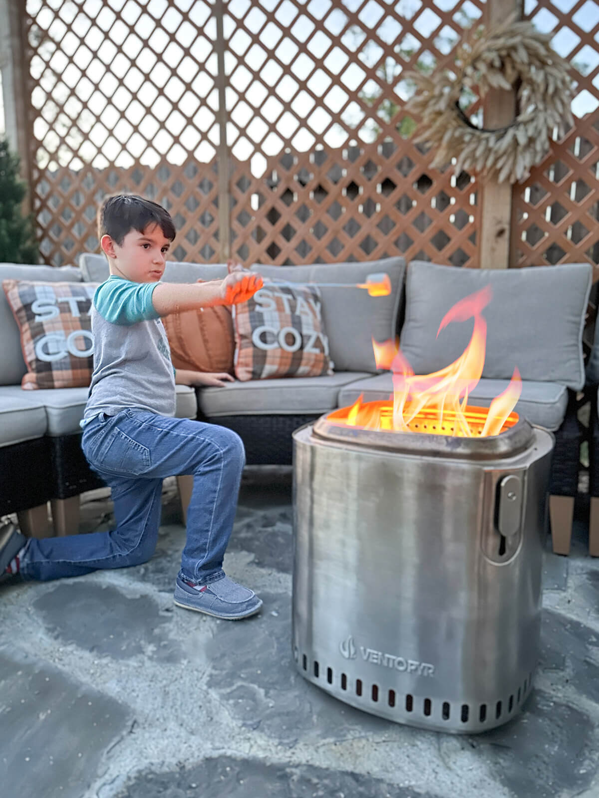 A little boy is roasting marshmallows using a smokeless fire pit